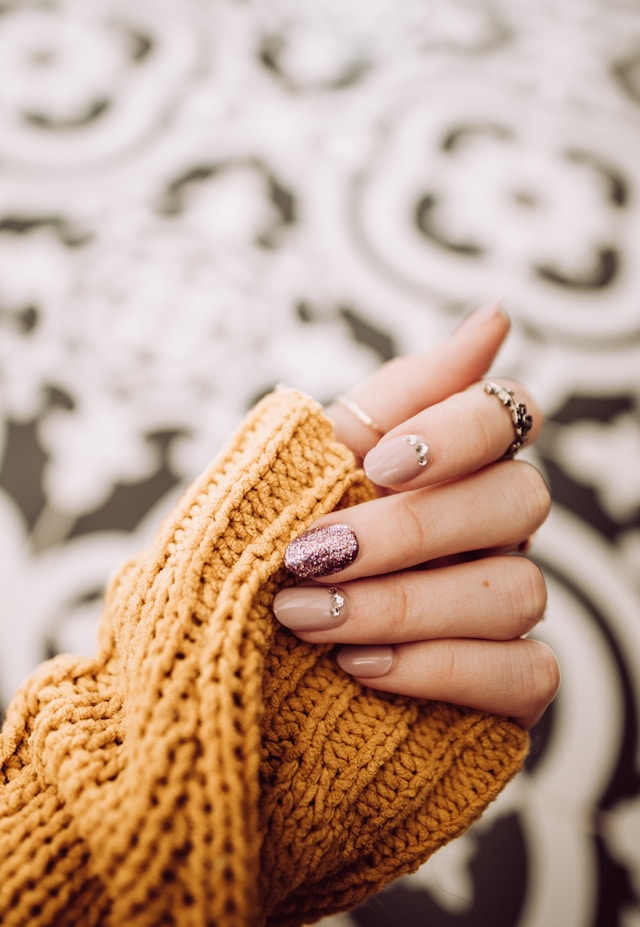 Nude manicure with rose glitter accent on knit