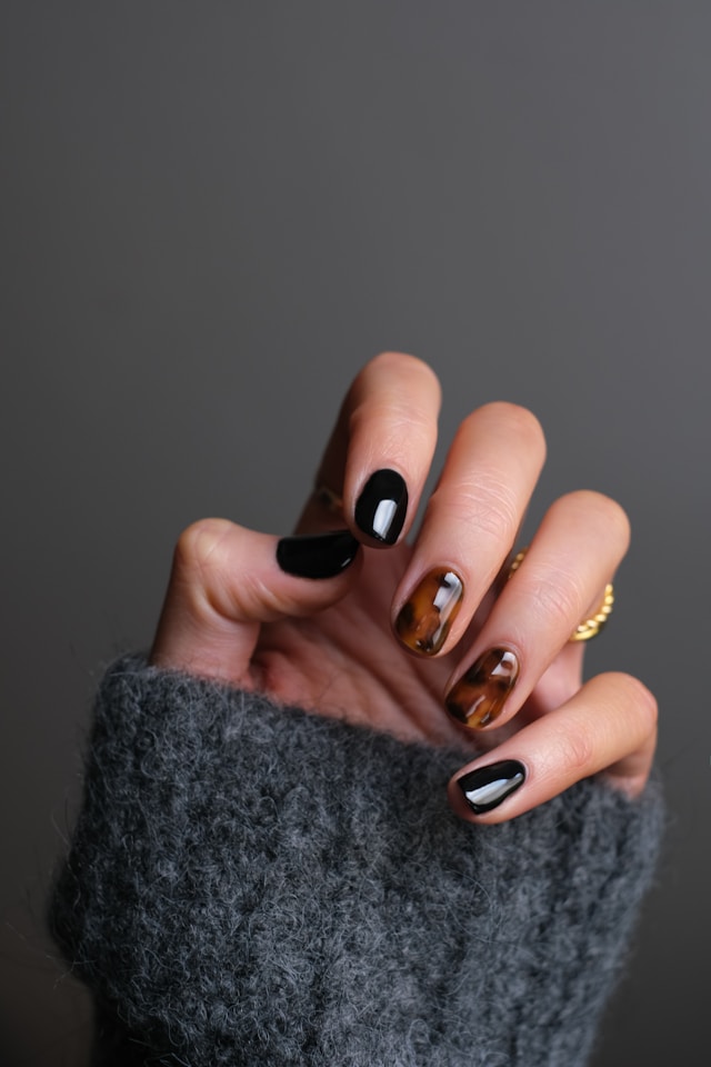 Black and tortoiseshell marbled nails on grey sweater