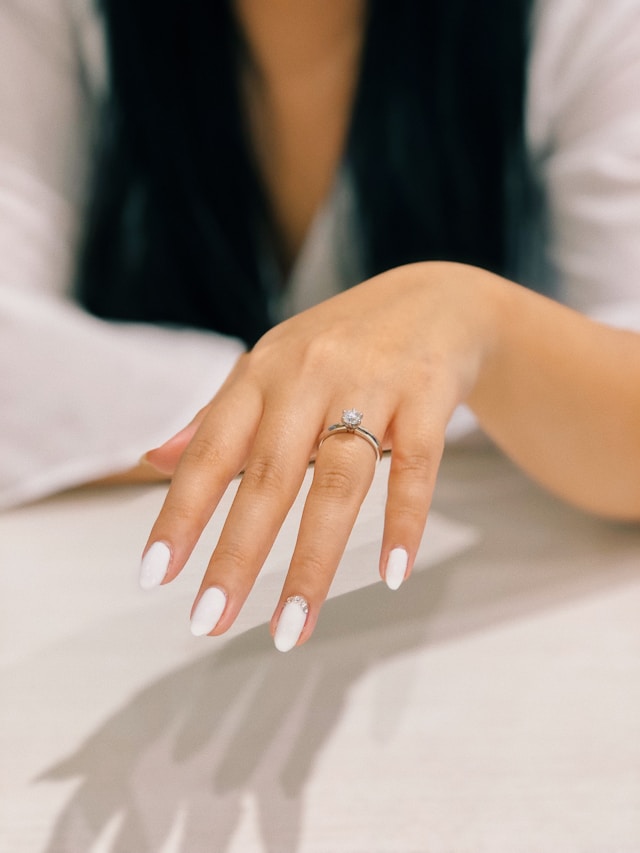 Classic white bridal manicure with engagement ring